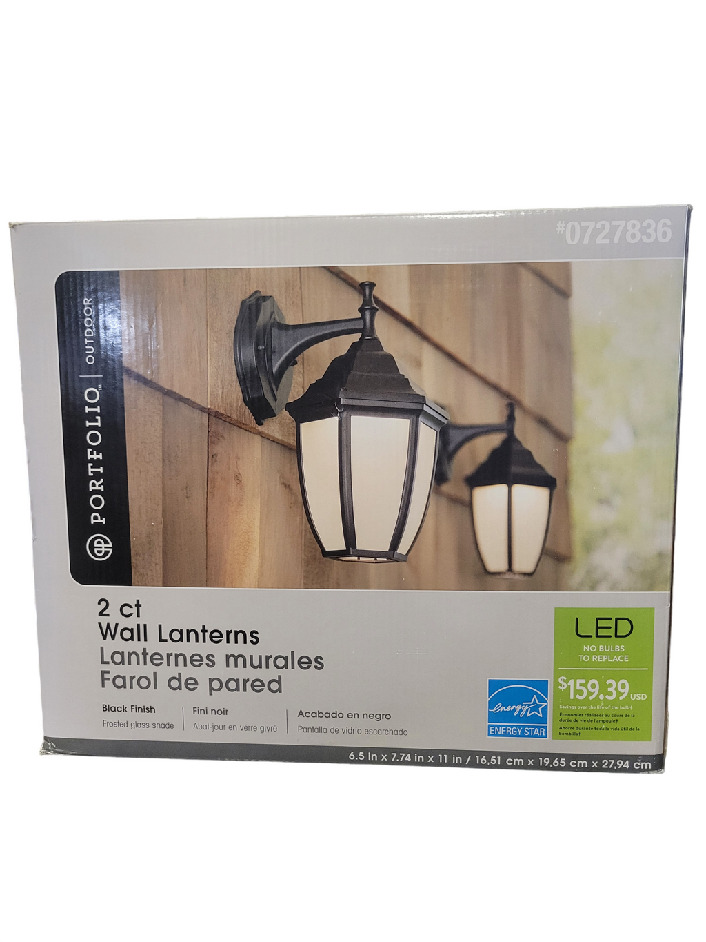 Packaging of two outdoor wall lanterns with a wooden fence background