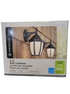 Packaging of two outdoor wall lanterns with a wooden fence background