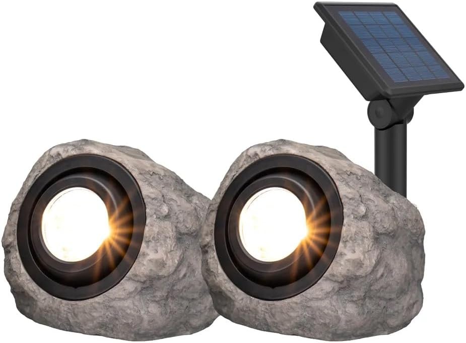 Two stone-like solar lights with a solar panel on a white background