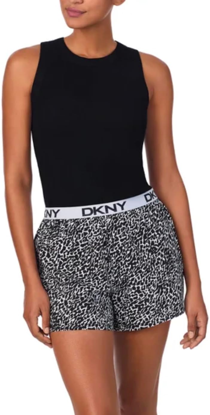 Woman wearing a black sleeveless top and patterned shorts with DKNY waistband on a white background