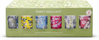 Set of six fragranced candles in colorful glass containers with floral designs on a green box labeled 'Simply Indulgent'.
