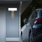 Security camera mounted on a garage wall with a car parked nearby