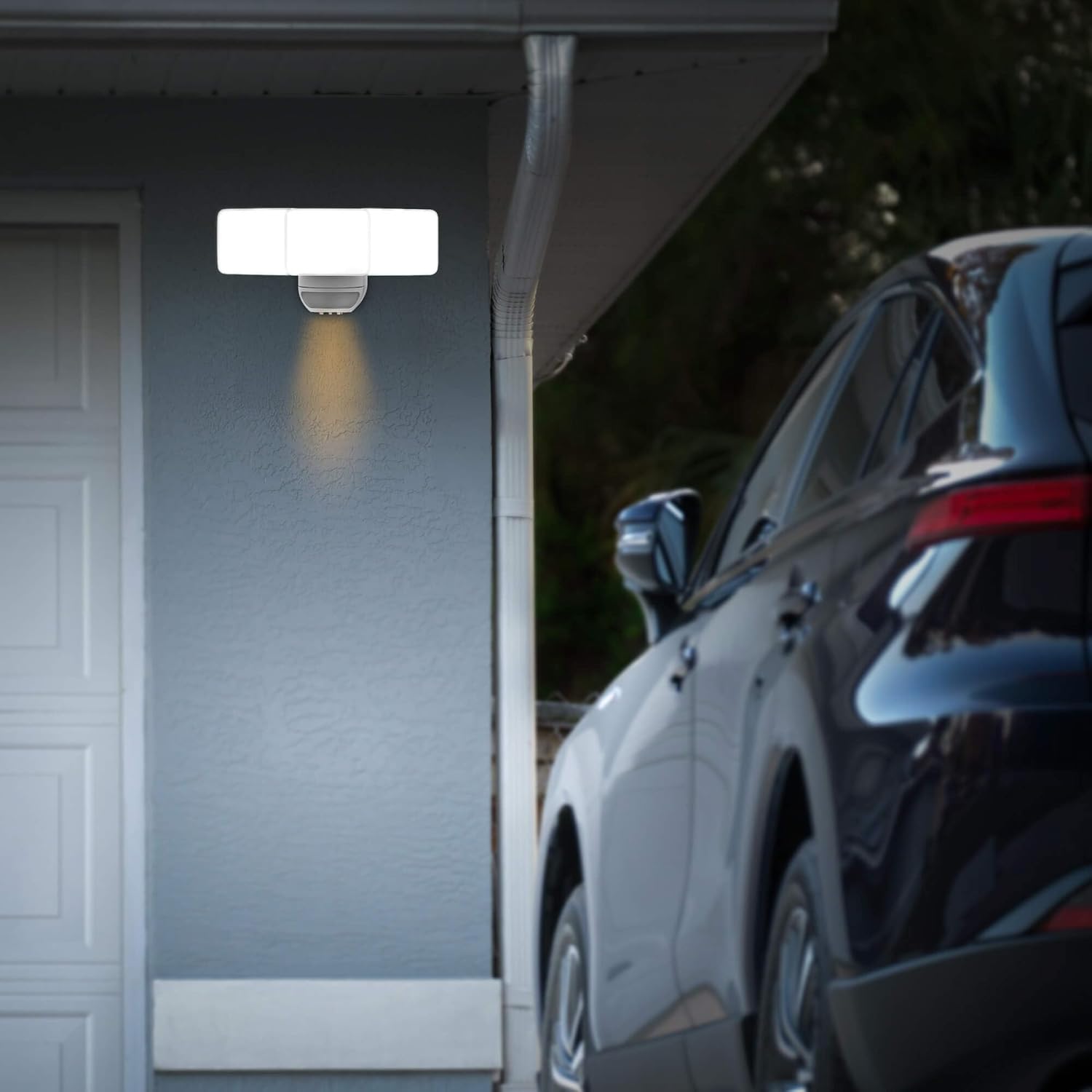 Security camera mounted on a garage wall with a car parked nearby
