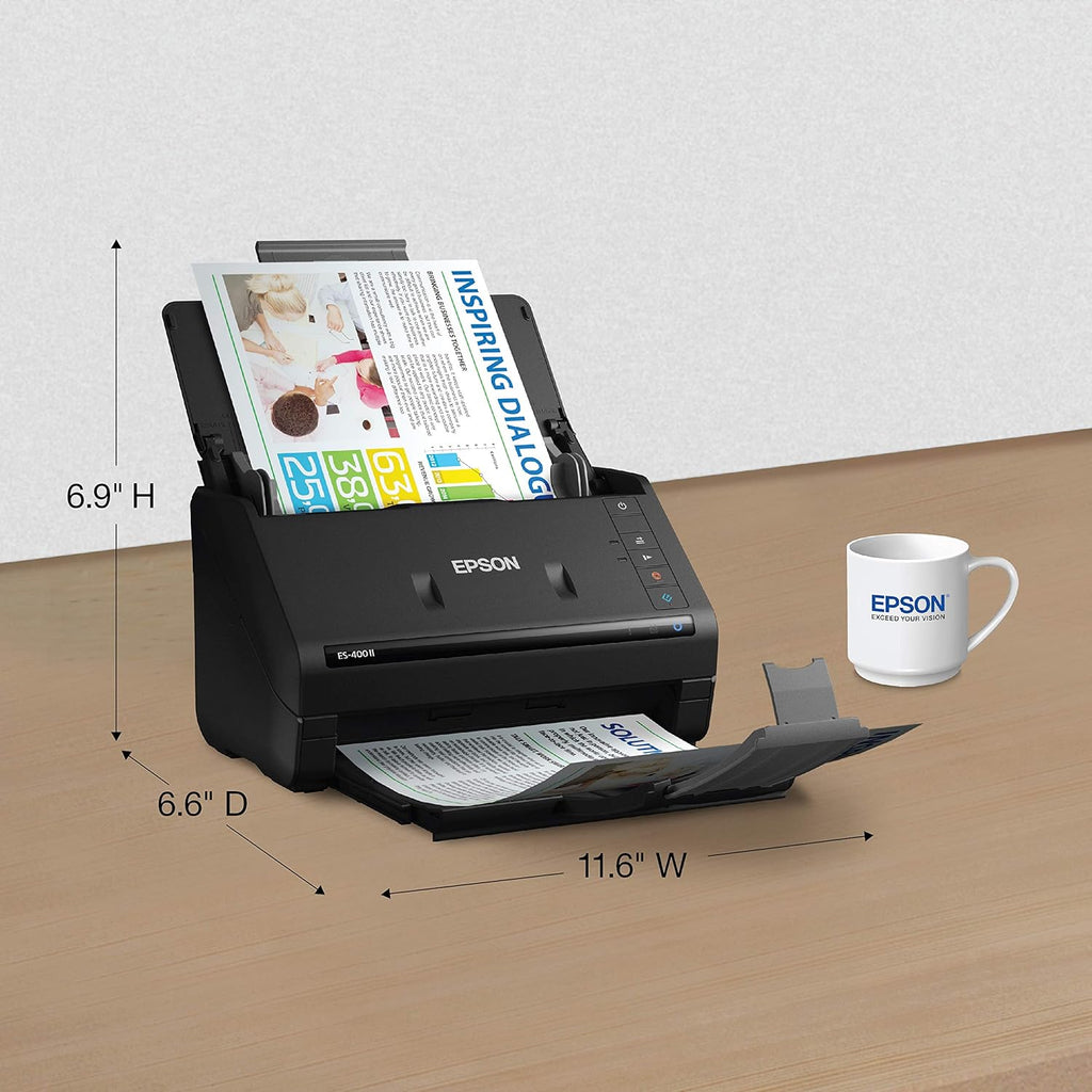 Epson scanner with dimensions displayed on a wooden surface, next to an Epson mug.
