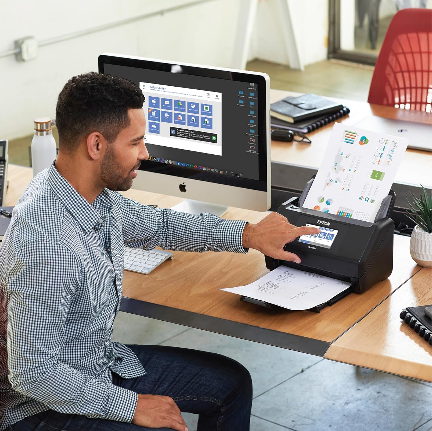 Man using an Epson scanner at a desk with a computer in the background