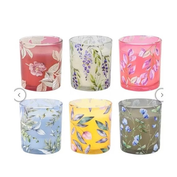Set of six floral-patterned glass containers on a white background